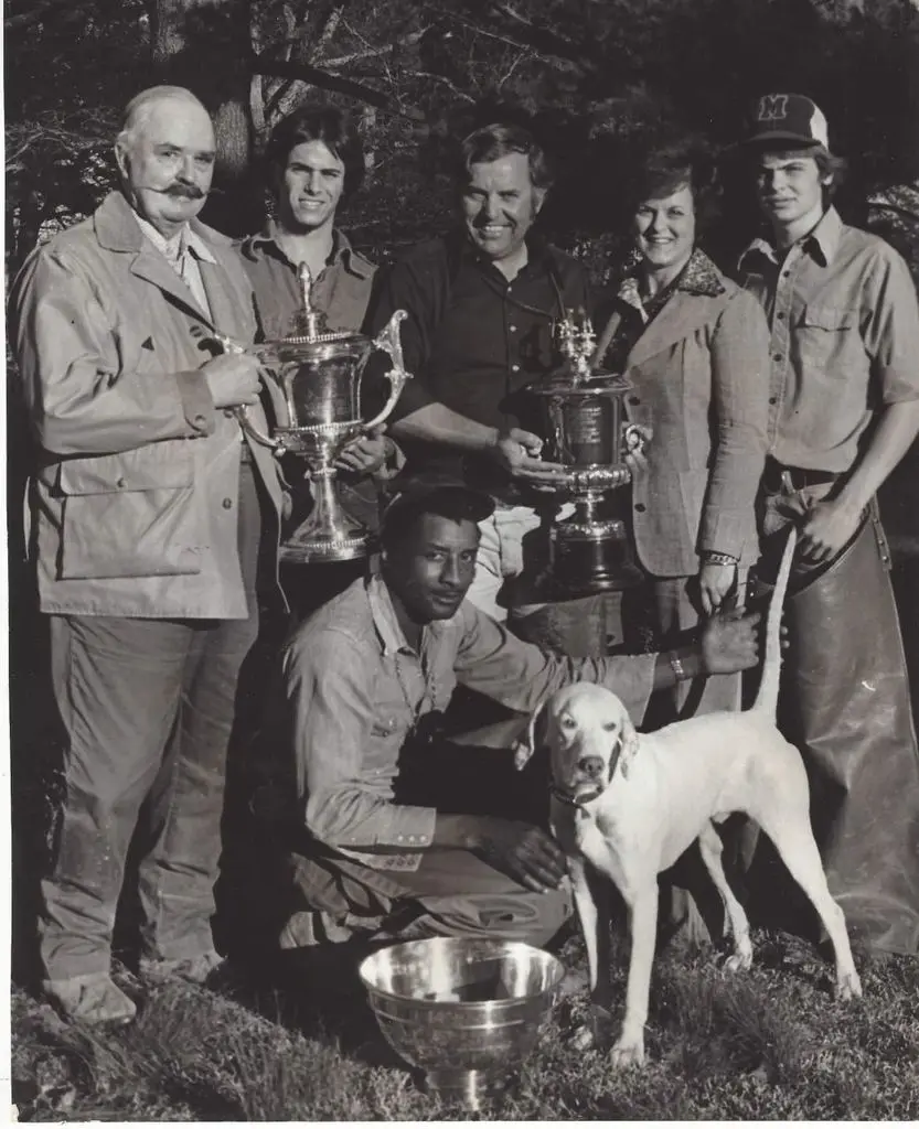 1970s black-and-white winner’s circle with two silver cups and a white pointer
